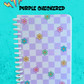 Notebook with purple checkered pattern and floral designs on a turquoise background