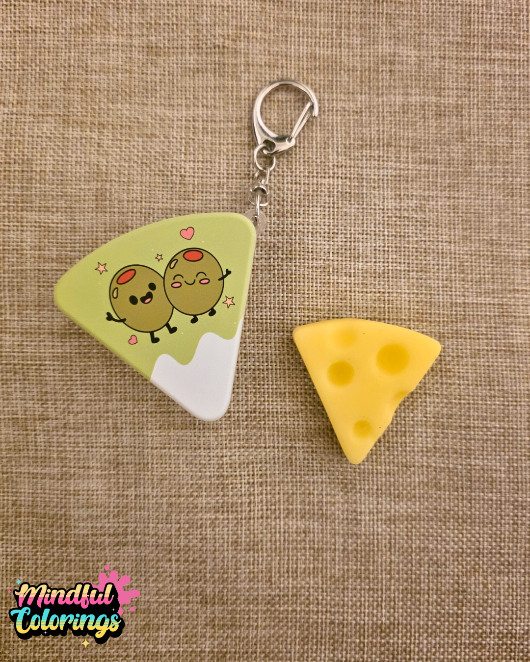 Cheese shaped fidget keychain with cartoon olives on the front