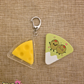 Cheese shaped fidget keychain with cartoon olives on the front