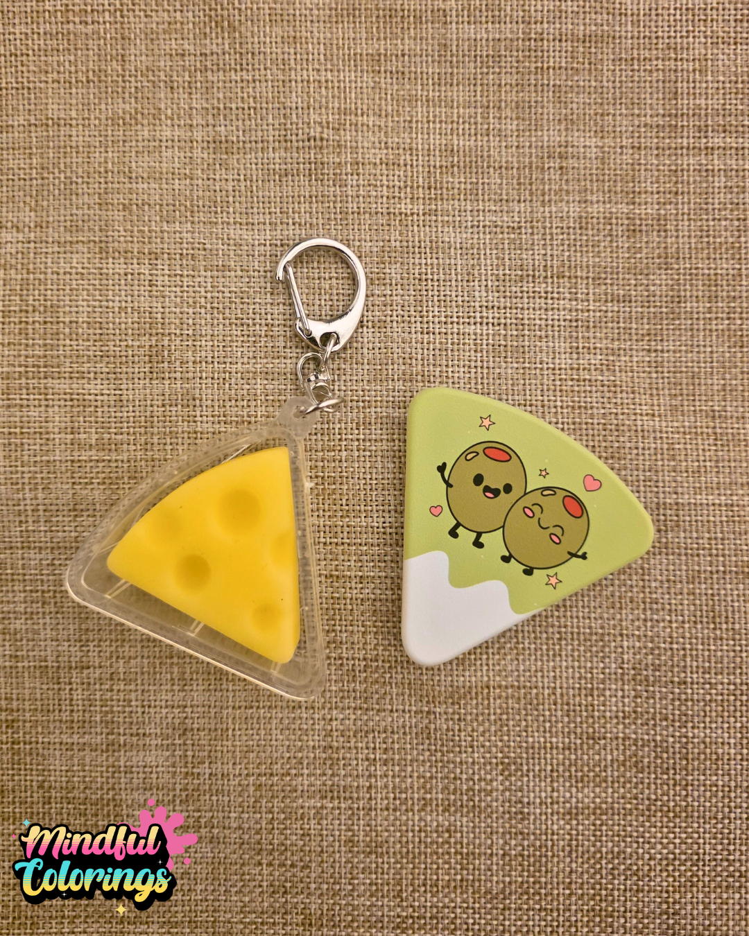 Cheese shaped fidget keychain with cartoon olives on the front