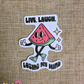 Sticker with a watermelon character and text 'Live, Laugh, Losing My Mind' on a textured brown background.