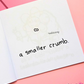 Mini colouring book page featuring an extremely tiny crumb with a face and the caption "a smaller crumb."