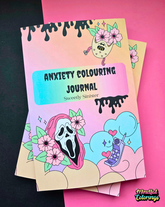 Anxiety Colouring Journal called Sweety Sinister, featuring a pastel pink and blue gradient cover with cartoon illustrations of a ghost mask, flowers, a phone, and clouds, shown on a split black and pink background.