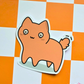 Waterproof vinyl sticker featuring a chubby peach-colored cat with wide eyes on an orange checkered background.