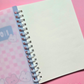 Pink spiral-bound A6 notebook featuring a kawaii checkered cover with cute bunny and bear characters.
