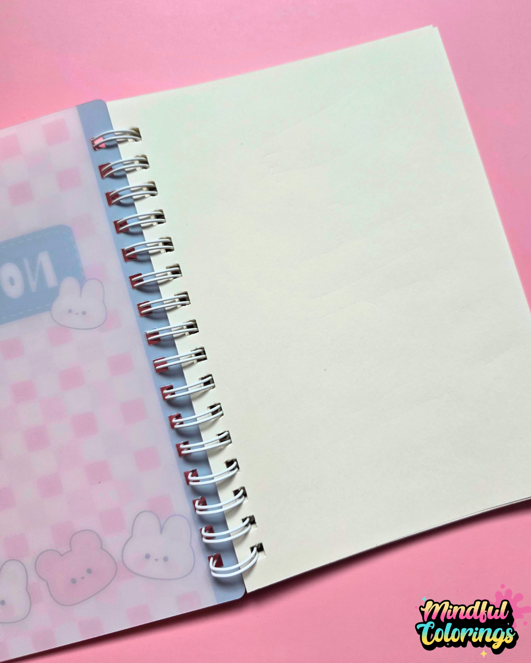 Pink spiral-bound A6 notebook featuring a kawaii checkered cover with cute bunny and bear characters.