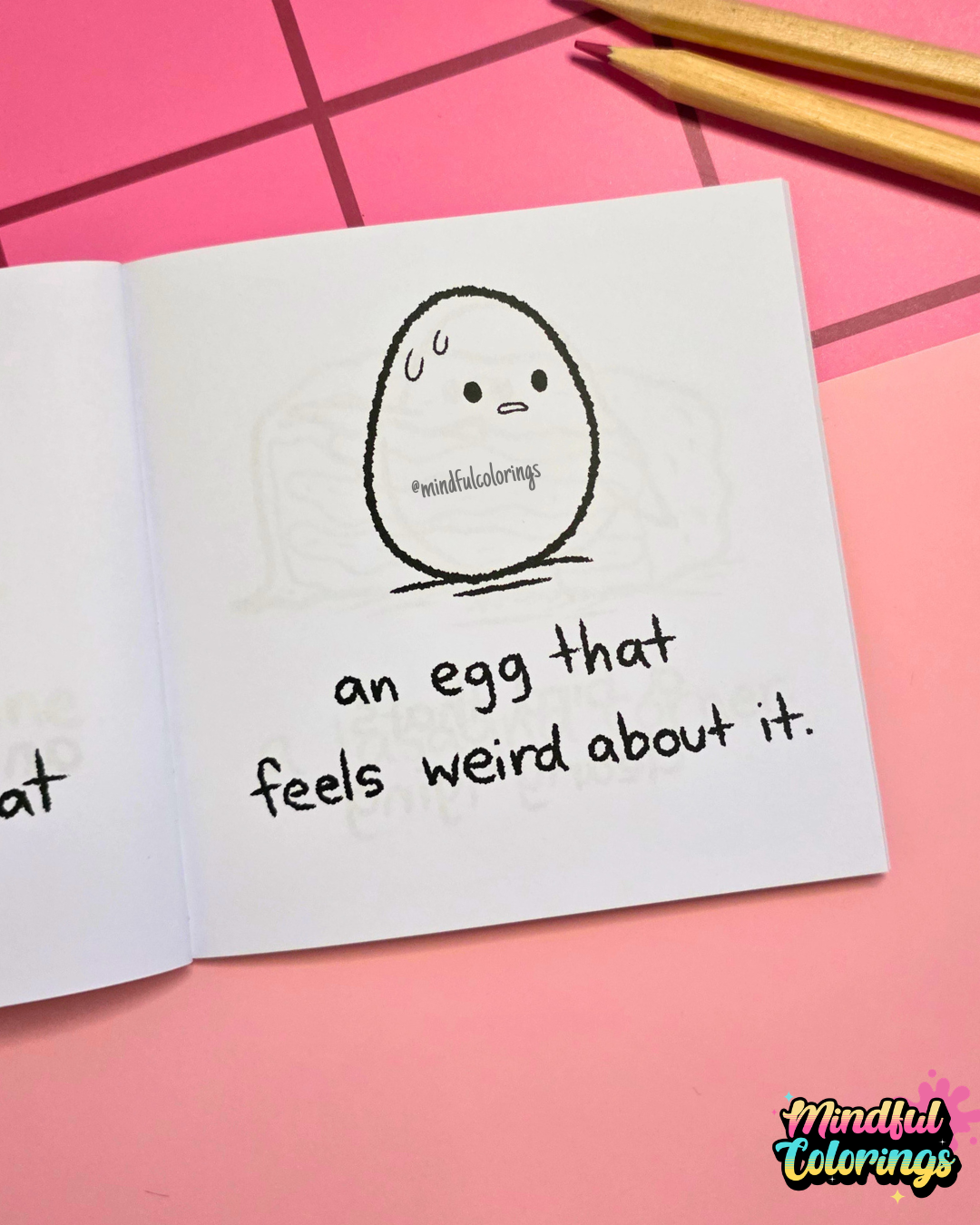 Mini coloring book with a cartoon egg and text that says "an egg that feels weird about it" on a pink surface