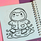 Mini frog-themed colouring book page featuring a cheerful frog wearing a raincoat and rain boots while splashing in a puddle.