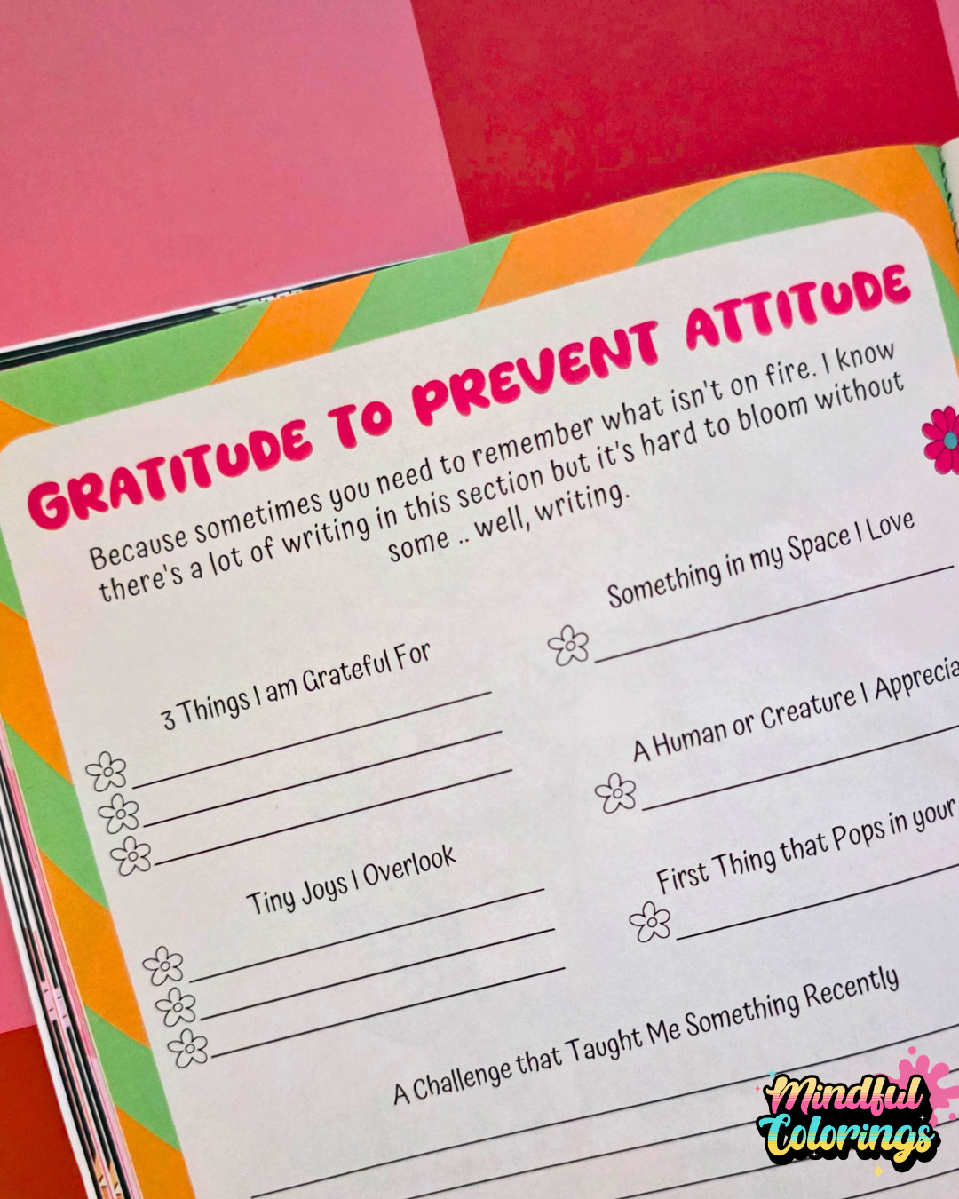 Colorful gratitude journal with prompts on a pink background