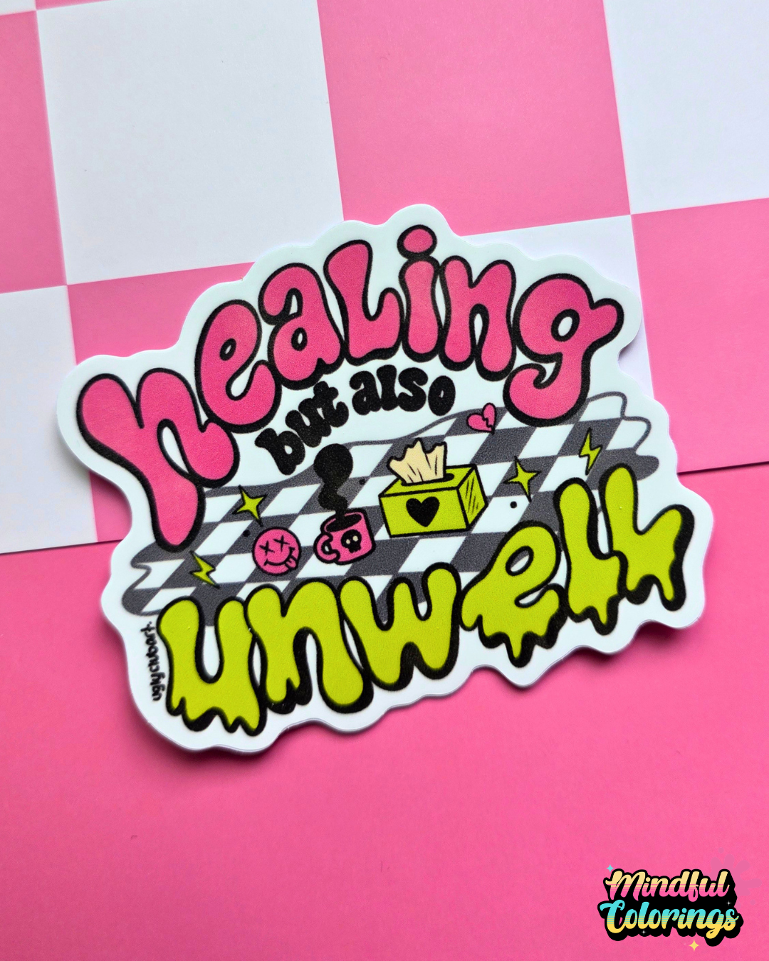 Waterproof vinyl sticker featuring the phrase "Healing but also unwell" in colorful bubble lettering with playful illustrations on a pink checkered background.