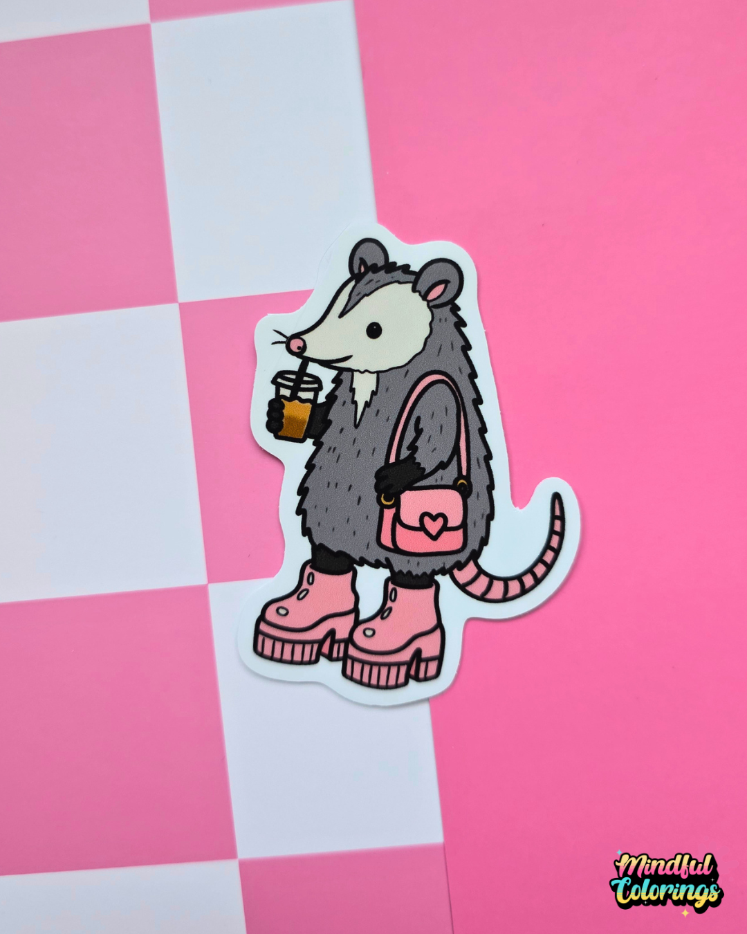 Cute opossum vinyl sticker holding an iced coffee and wearing pink platform boots with a matching heart purse on a pink background.