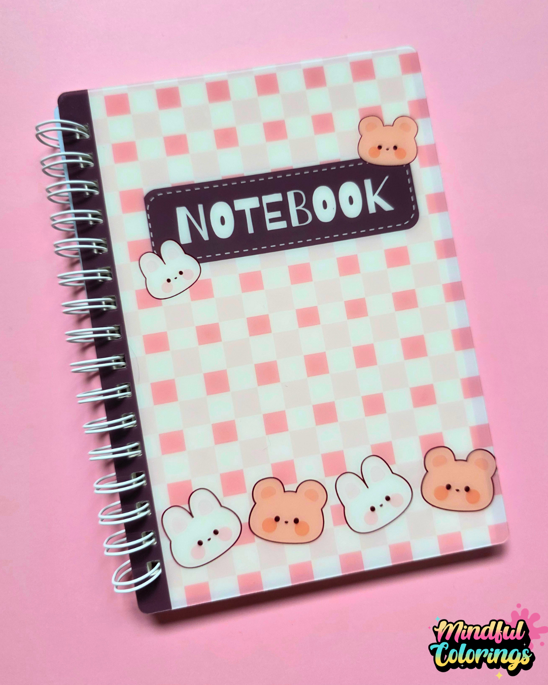 Pink spiral-bound A6 notebook featuring a kawaii checkered cover with cute bunny and bear characters.