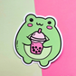 Waterproof vinyl sticker featuring a cute green frog holding a pink bubble tea drink on a pink and mint background.