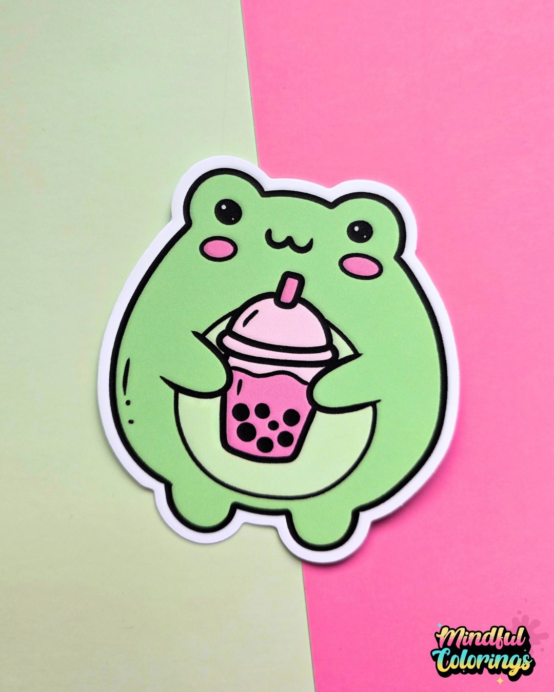 Waterproof vinyl sticker featuring a cute green frog holding a pink bubble tea drink on a pink and mint background.