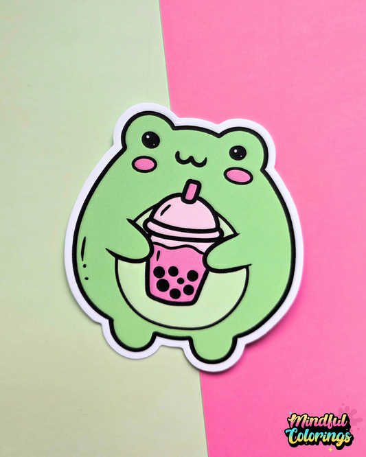 Waterproof vinyl sticker featuring a cute green frog holding a pink bubble tea drink on a pink and mint background.