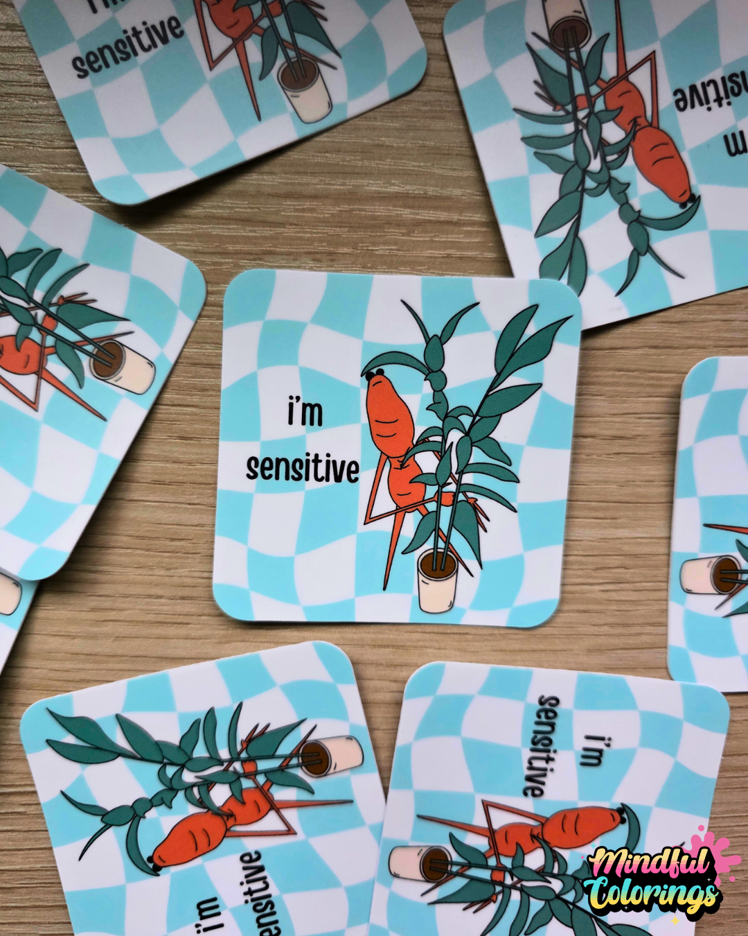 Stickers with the viral Marcus the Worm character hiding behind a green houseplant with the text "I'm Sensitive" with a blue checkered background