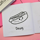 Mini coloring book with a cute hot dog illustration with text that says "Dawg" on a pink surface