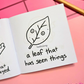 Mini coloring book with a leaf illustration and text  that says "a leaf with trust issues" on a pink surface