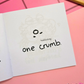 Mini colouring book page featuring a tiny crumb with a face and the caption "one crumb."
