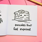 Mini coloring book with a drawing of pancakes and text 'pancakes that feel exposed' on a pink surface