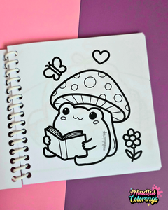 Mini frog-themed colouring book page featuring a cute frog reading a book while sitting beneath a spotted mushroom, surrounded by a butterfly, flower, and heart.
