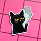 Vinyl sticker featuring a grumpy black cat holding a cigarette with smoke rising above it on a pink checkered background.