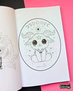 An open coloring book or art booklet showing a black-and-white line drawing of a cute baphomet inside an oval frame, placed on a bright pink background with part of another page visible on the left.