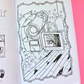 An open coloring book or activity booklet showing a black-and-white illustrated page with a camera, a phone screen with Blair Witch Movies background, placed on a bright pink background.