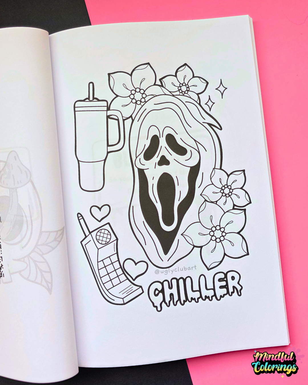 An open coloring book or art journal page featuring a black-and-white Ghostface Horror themed illustration with flowers, a tumbler, a phone, hearts, and the word 'CHILLER.' The page is photographed on a bright pink background with a small 'Mental Colorings' logo in the bottom right corner.