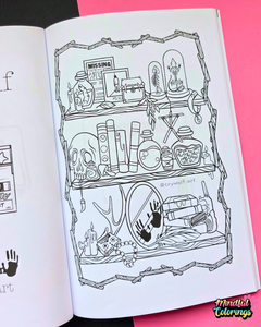 An open coloring book or art booklet showing a black-and-white illustrated page with shelves of occult and gothic objects like a skull, cauldron, books, and mirrors, placed against a bright pink background.