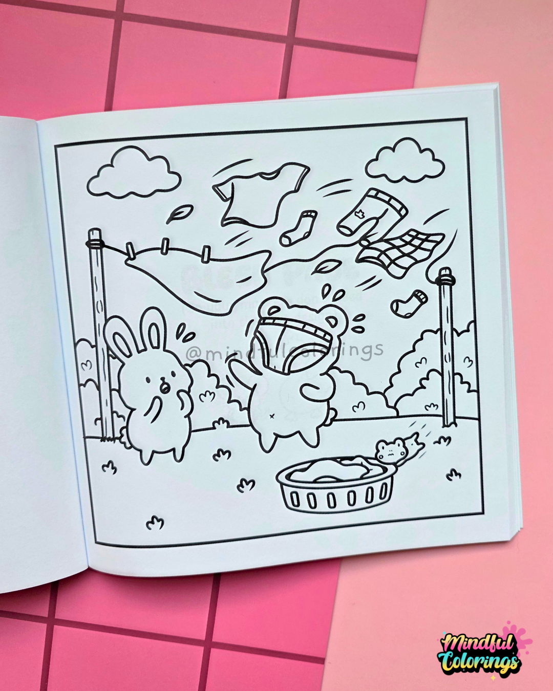 Page from Tiny Mishaps: A Chaotic Coloring Book featuring a bear and bunny watching laundry blow away from a clothesline on a windy day. Cute animal coloring book designed for stress relief, relaxation, mindfulness, and marker-friendly coloring.