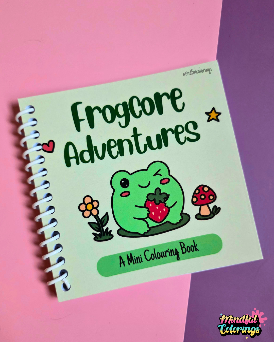 Mini 4x4-inch Frogcore Adventures coloring book featuring cute frog-themed illustrations, coiled binding, and 46 double-sided pages filled with whimsical frog adventures and cozy nature-inspired scenes.