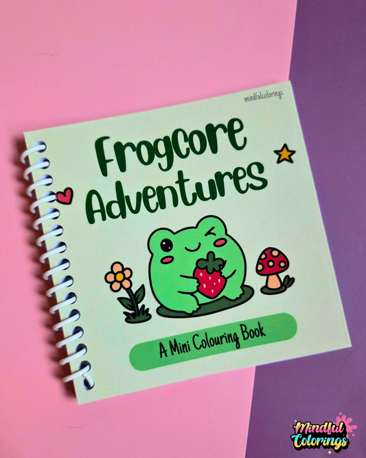 Mini 4x4-inch Frogcore Adventures coloring book featuring cute frog-themed illustrations, coiled binding, and 46 double-sided pages filled with whimsical frog adventures and cozy nature-inspired scenes.
