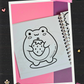 Cute frog holding a large strawberry coloring page from the Frogcore Adventures mini coloring book featuring a whimsical frogcore illustration.