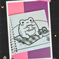 Cute frog enjoying a picnic on a checkered blanket beside a basket of treats coloring page from the Frogcore Adventures mini coloring book.