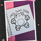 Cute frog wearing flower-patterned swim floaties with the words Frog Swim School coloring page from the Frogcore Adventures mini coloring book.