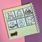 Mini 4x4-inch Frogcore Adventures coloring book featuring cute frog-themed illustrations, coiled binding, and 46 double-sided pages filled with whimsical frog adventures and cozy nature-inspired scenes.