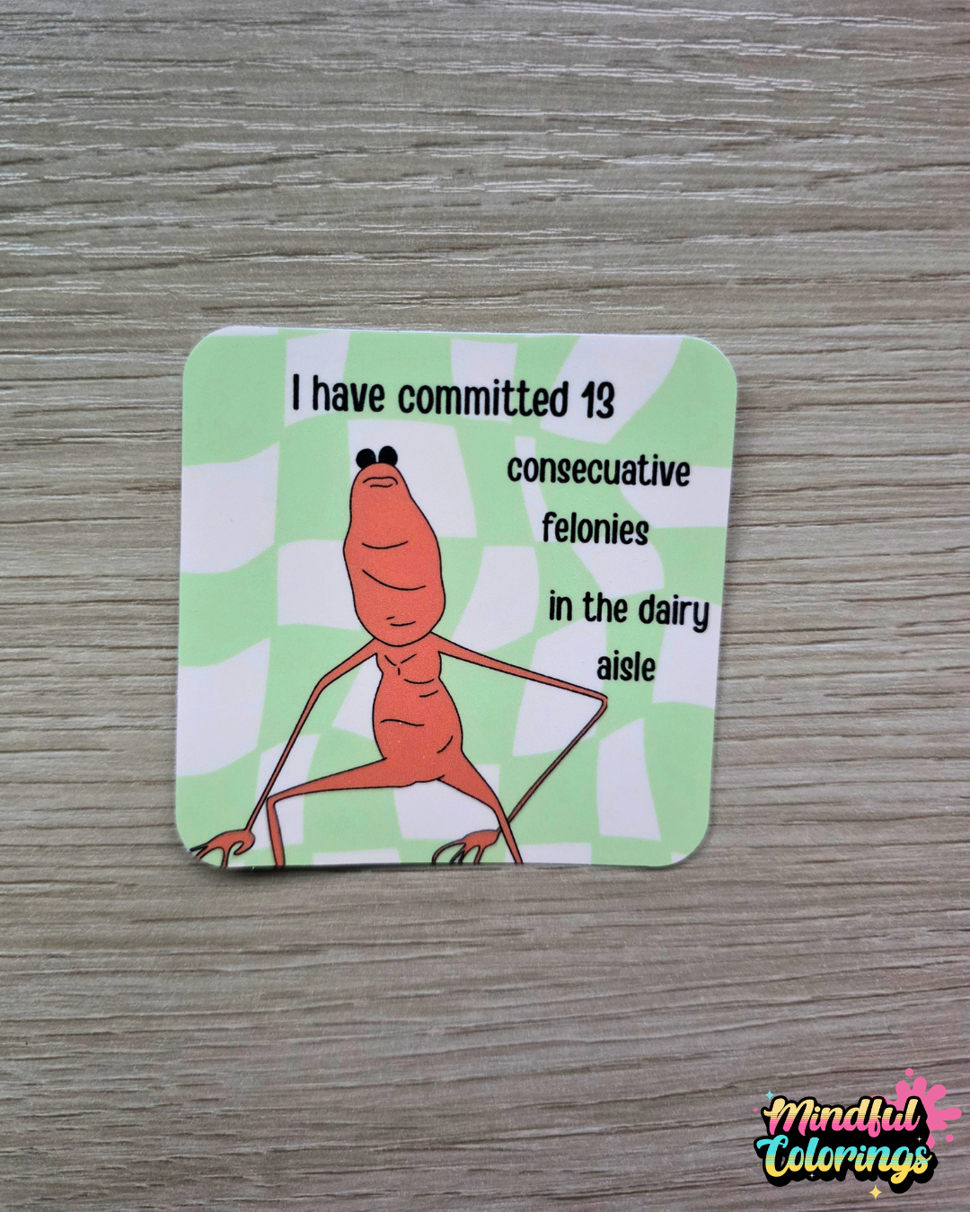 Sticker featuring Marcus the Worm with a confident stance beside the text "I have committed 13 consecutive felonies in the dairy aisle" on a green checkered background.